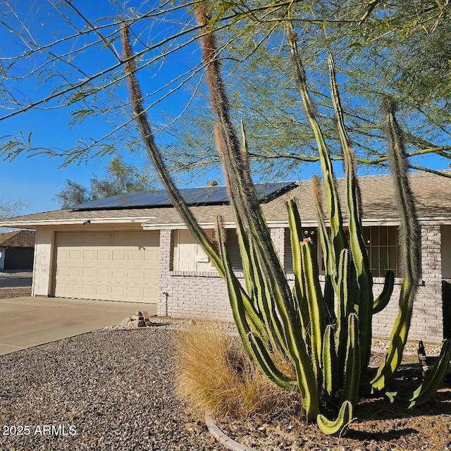 view of front of home featuring solar panels and a garage