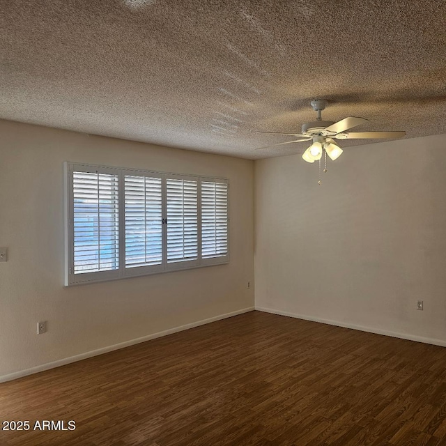 empty room with ceiling fan, dark hardwood / wood-style flooring, and a textured ceiling