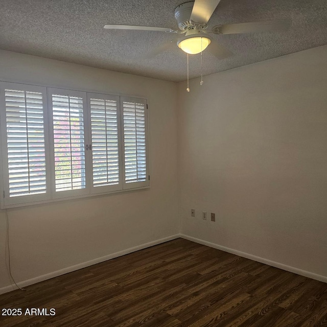 empty room featuring ceiling fan, dark wood-type flooring, and a textured ceiling