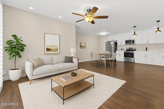 living room featuring dark wood finished floors, ceiling fan, recessed lighting, and baseboards