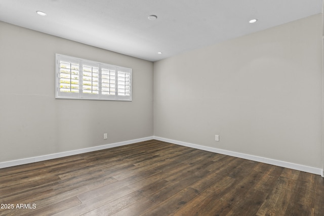 spare room with dark wood finished floors, baseboards, and recessed lighting