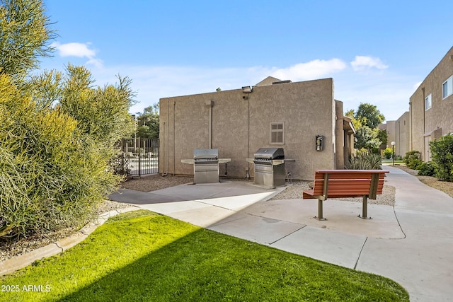 back of house featuring stucco siding, a patio, and fence