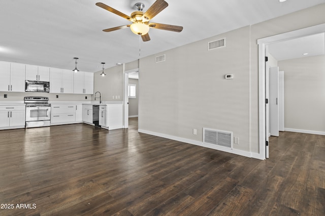 unfurnished living room with dark wood-style floors, ceiling fan, and baseboards