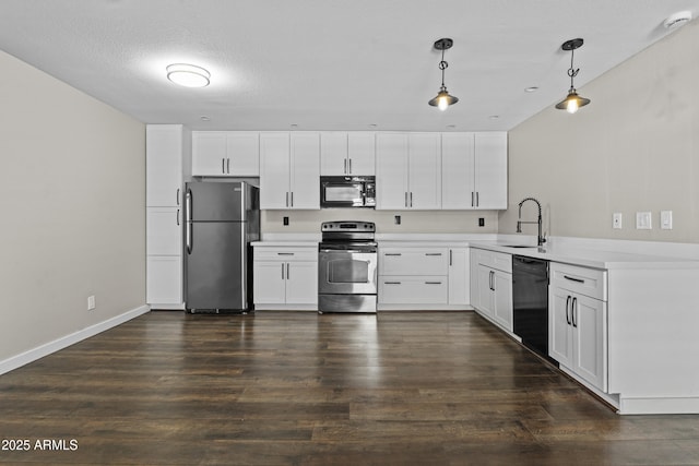 kitchen with black appliances, a sink, light countertops, decorative light fixtures, and dark wood-style floors