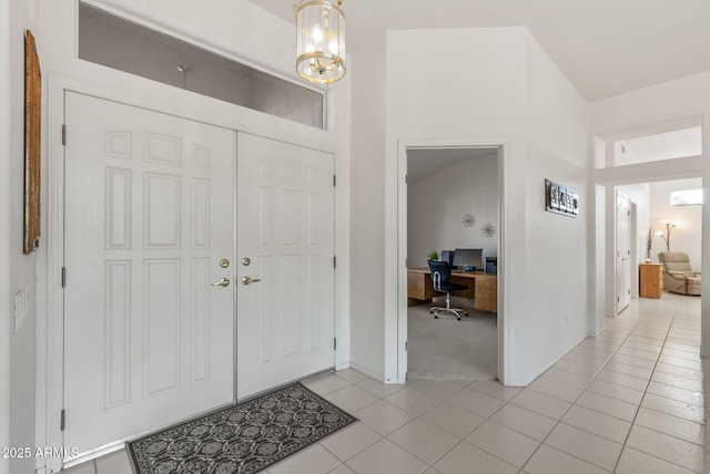 entrance foyer featuring light tile patterned flooring, a chandelier, and baseboards