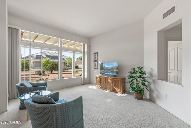 living area with visible vents and carpet flooring