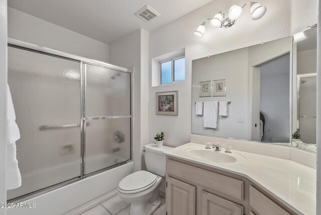 bathroom with visible vents, toilet, vanity, and enclosed tub / shower combo