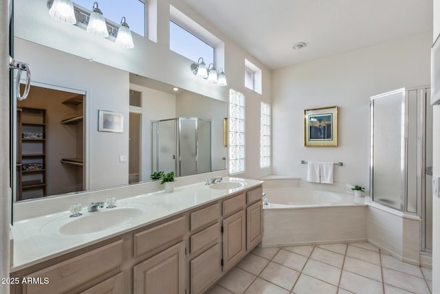 bathroom featuring a shower stall, a bath, a sink, and double vanity