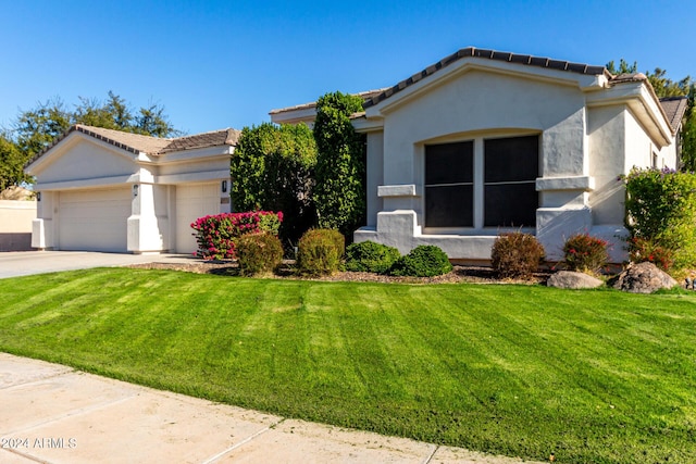 view of front of home with a garage and a front lawn