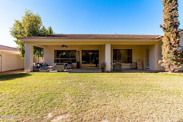 back of property featuring an outdoor living space, ceiling fan, a patio area, and a lawn