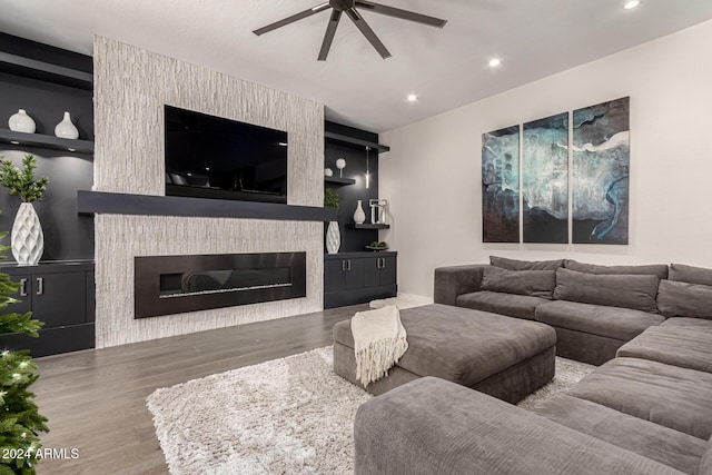 living room featuring ceiling fan, wood-type flooring, and a fireplace