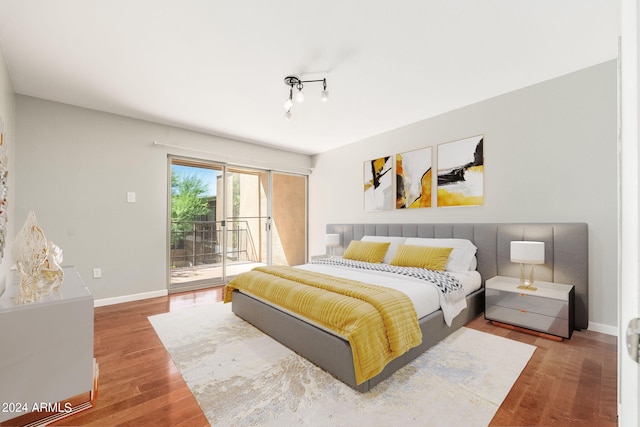 bedroom with wood-type flooring and access to outside