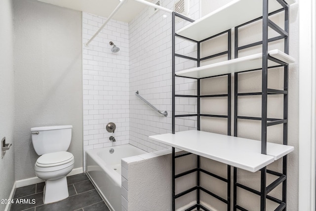 bathroom featuring tiled shower / bath combo, toilet, and tile patterned flooring