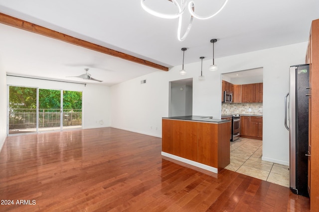 kitchen featuring hanging light fixtures, ceiling fan with notable chandelier, light hardwood / wood-style flooring, and stainless steel appliances