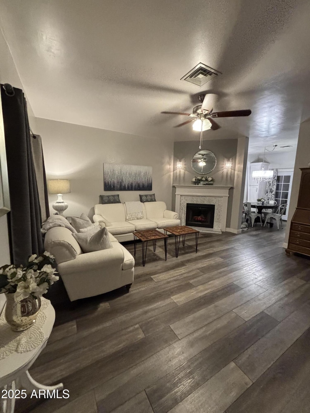 1601 N Saba St Unit 255, Chandler, AZ 85225 - living area with a ceiling fan, a fireplace, a textured ceiling, and dark wood-style flooring