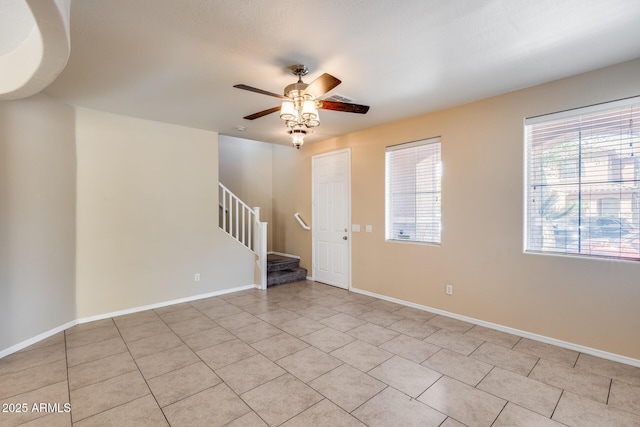 9 N 87th Ln N, Tolleson, AZ 85353 - empty room with stairway, ceiling fan, light tile patterned floors, and baseboards
