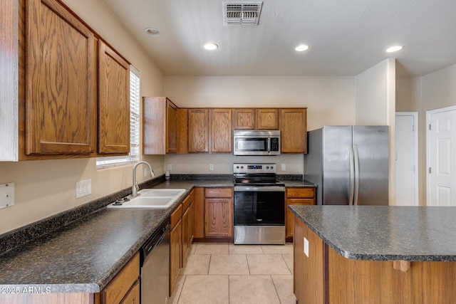 9 N 87th Ln N, Tolleson, AZ 85353 - kitchen with appliances with stainless steel finishes, a sink, brown cabinets, dark countertops, and recessed lighting