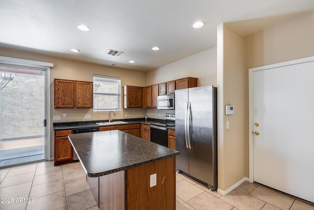 9 N 87th Ln N, Tolleson, AZ 85353 - kitchen featuring appliances with stainless steel finishes, a sink, dark countertops, brown cabinetry, and recessed lighting