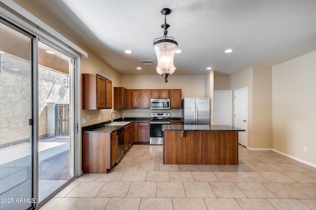 9 N 87th Ln N, Tolleson, AZ 85353 - kitchen with stainless steel appliances, a sink, a center island, brown cabinetry, and light tile patterned floors