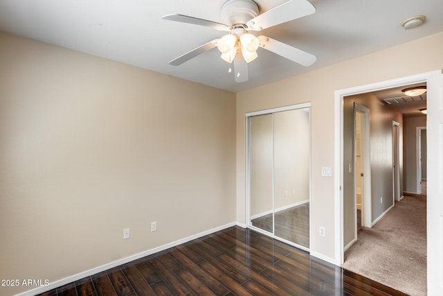 9 N 87th Ln N, Tolleson, AZ 85353 - unfurnished bedroom featuring dark wood-style floors, baseboards, a closet, and a ceiling fan