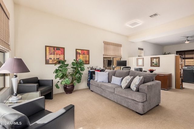 living room featuring beamed ceiling, light carpet, and ceiling fan