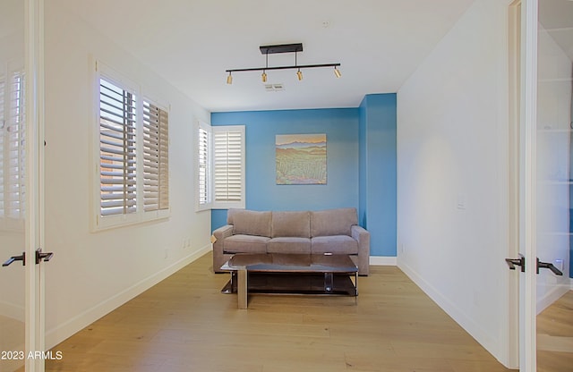 sitting room with light hardwood / wood-style flooring, french doors, and track lighting