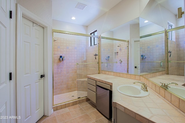 bathroom featuring a shower with door, vanity, and tile patterned floors