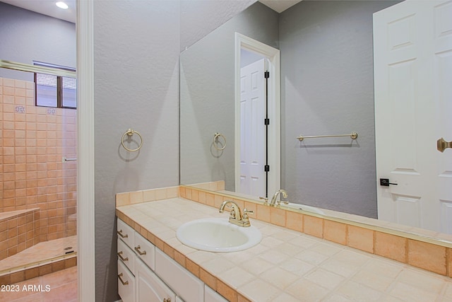 bathroom with vanity and tiled shower