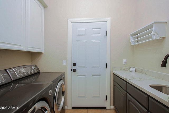 laundry area featuring cabinets, washer and dryer, sink, and light tile patterned floors