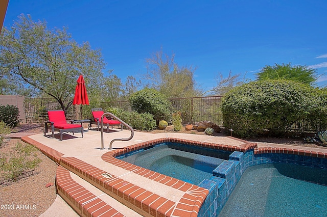 view of swimming pool with an in ground hot tub and a patio