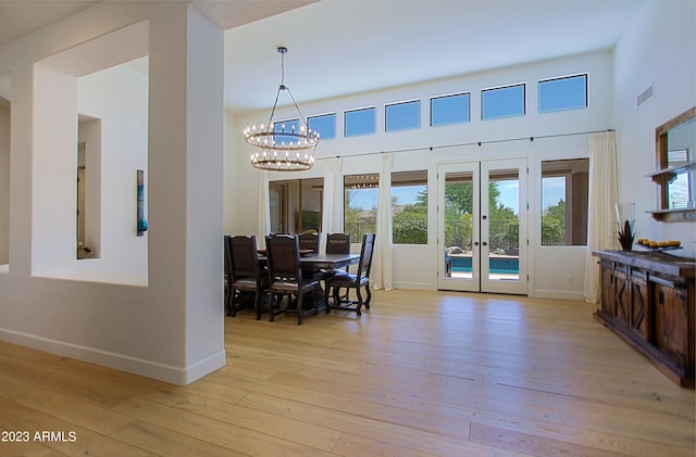 dining space featuring a chandelier, french doors, and light hardwood / wood-style floors