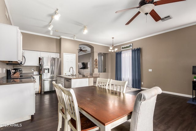 dining space featuring sink, dark wood-type flooring, and ornamental molding