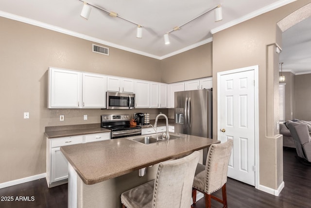 kitchen with stainless steel appliances, a kitchen island with sink, sink, and white cabinets