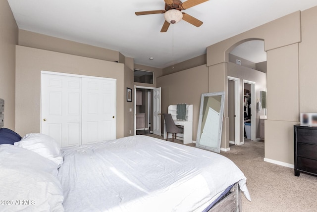 bedroom with ceiling fan, light carpet, and a closet