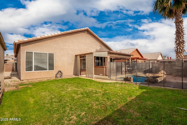 rear view of house with a fenced in pool, a patio area, and a lawn