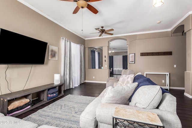 living room with ornamental molding, dark wood-type flooring, and ceiling fan