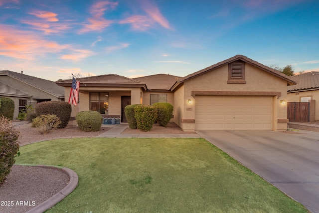 view of front of property with a tiled roof, an attached garage, driveway, and stucco siding