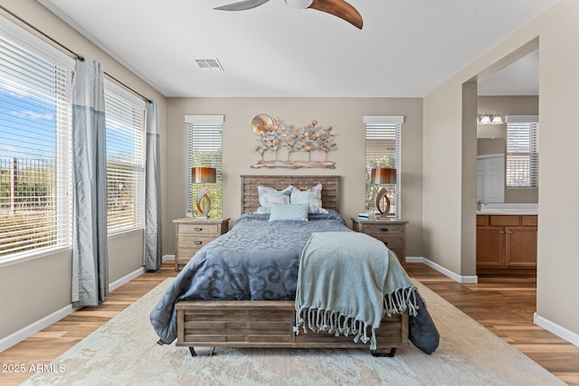 bedroom with multiple windows, light wood-type flooring, visible vents, and baseboards