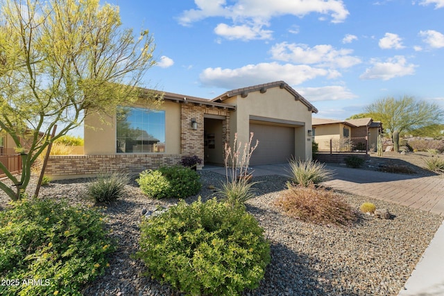 view of front of home featuring decorative driveway, brick siding, stucco siding, fence, and a garage