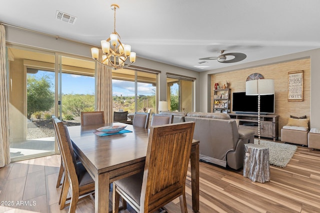 dining area with ceiling fan with notable chandelier, wood finished floors, and visible vents