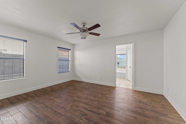 empty room with ceiling fan and dark hardwood / wood-style flooring