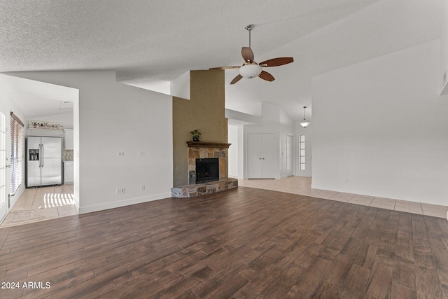 unfurnished living room featuring high vaulted ceiling, a textured ceiling, ceiling fan, and light hardwood / wood-style flooring