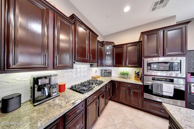 kitchen featuring visible vents, light stone counters, tasteful backsplash, and stainless steel appliances