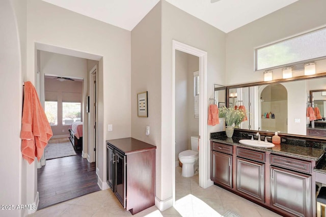ensuite bathroom featuring tile patterned flooring, vanity, ensuite bath, toilet, and a ceiling fan