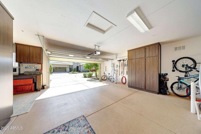 garage with a garage door opener and visible vents