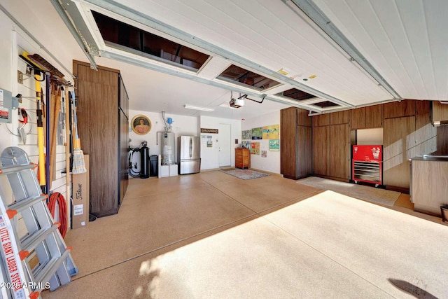 garage featuring wooden walls, gas water heater, a garage door opener, and freestanding refrigerator