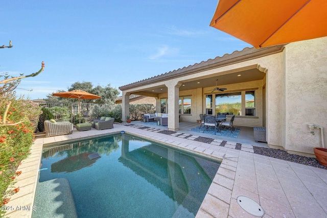 view of pool with fence, outdoor lounge area, a fenced in pool, a ceiling fan, and a patio