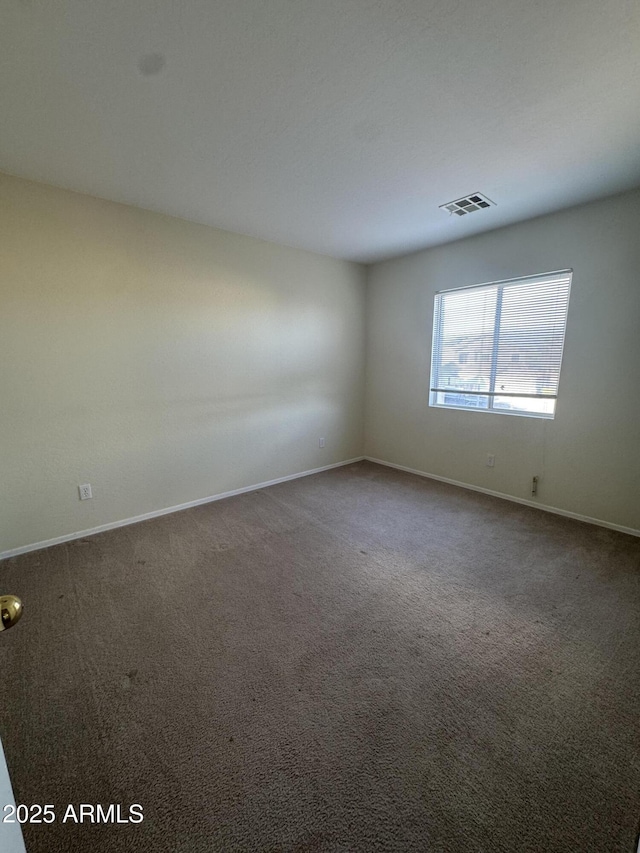 carpeted empty room featuring visible vents and baseboards