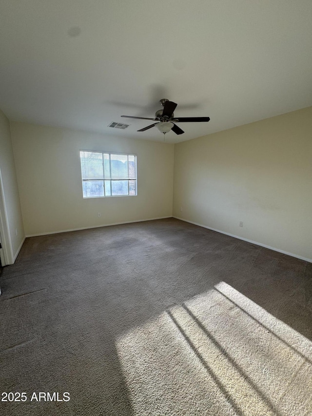 empty room with visible vents, a ceiling fan, baseboards, and carpet flooring