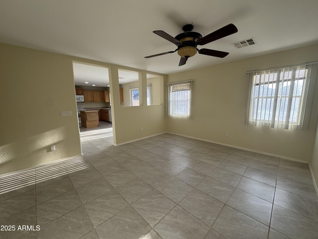 spare room with visible vents, baseboards, ceiling fan, and light tile patterned flooring